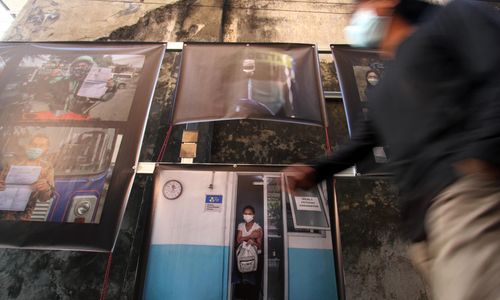 <p>Nampak sejumlah warga tengah melintas dan mengamati koleksi foto yang dipajang dalam pameran foto jurnalistik &#8221; meredaH Covid-19&#8243; yang digelar Pewarta Foto Indonesia Tangerang,di kawasan Pasar Lama Kota Tangerang. Foto : Panji Asmoro/TrenAsia</p>
