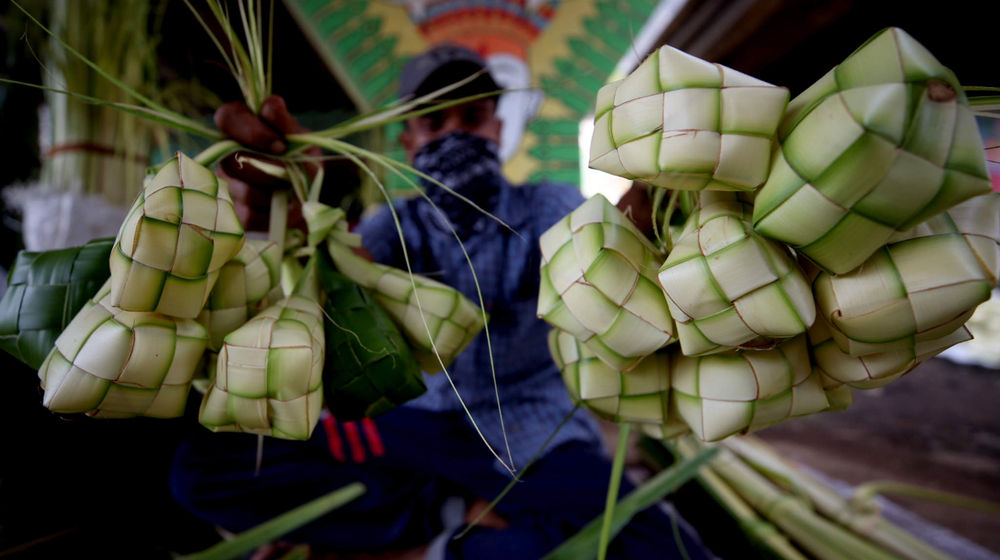 <p>Pedagang kulit ketupat musiman menggelar dagangannya di kawasan Pesanggerahan, Jakarta Selatan, Senin, 10 Mei 2021. Foto: Ismail Pohan/TrenAsia</p>