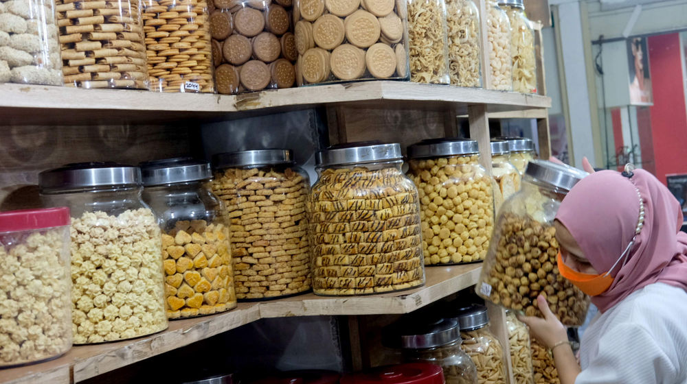 <p>Pedagang menata kue kering di kiosnya Pasar Mayestik, Jakarta Selatan, Senin, 3 Mei 2021. Foto: Ismail Pohan/TrenAsia</p>
