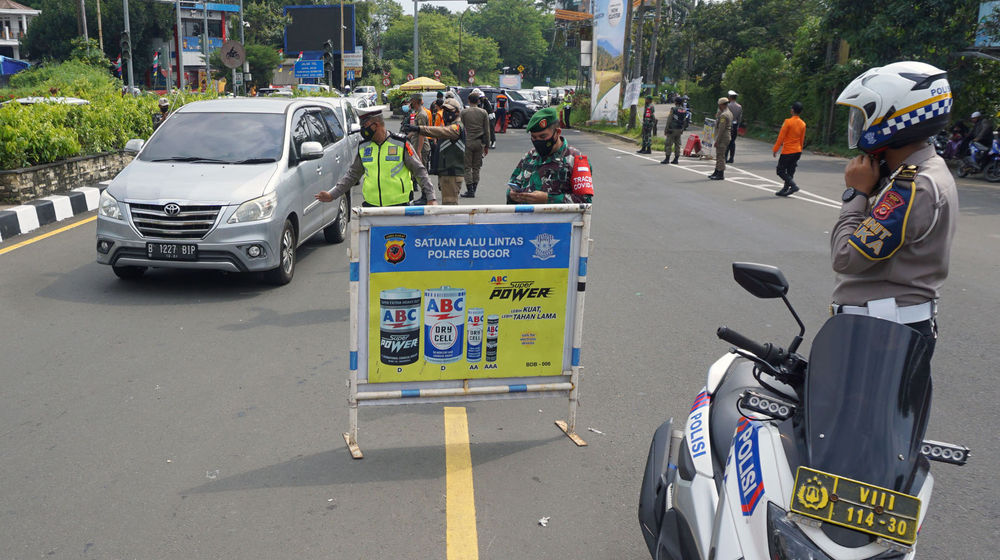 <p>Sejumlah petugas gabungan kepolisian,TNI dan Satpol PP  tengah melakukan penyekatan menuju jalur wisata Puncak Bogor, Sabtu 15 Mei 2021. Foto : Panji Asmoro/TrenAsia</p>
