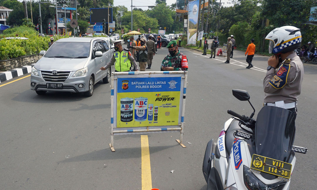 <p>Sejumlah petugas gabungan kepolisian,TNI dan Satpol PP  tengah melakukan penyekatan menuju jalur wisata Puncak Bogor, Sabtu 15 Mei 2021. Foto : Panji Asmoro/TrenAsia</p>
