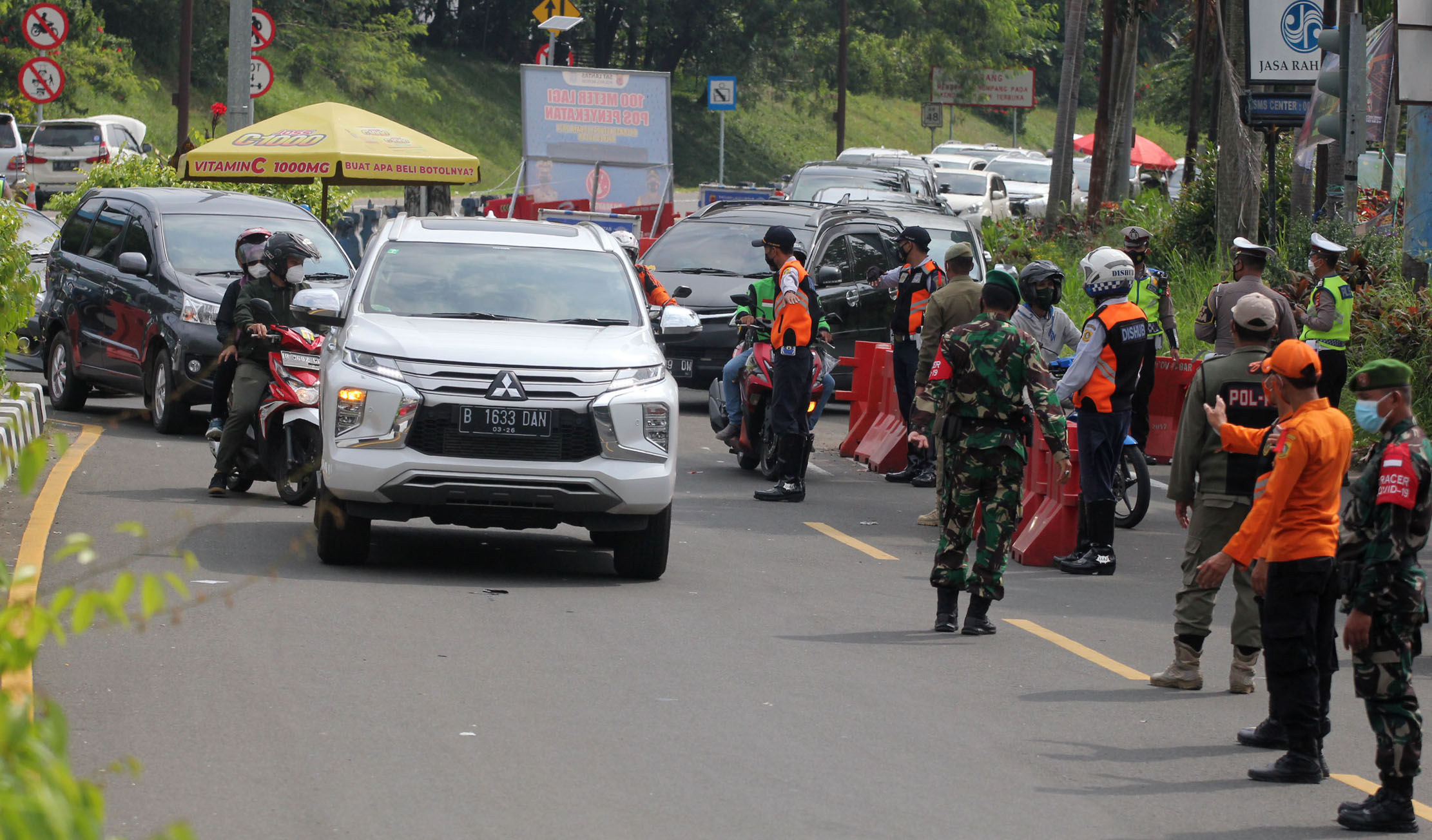 <p>Sejumlah petugas gabungan kepolisian,TNI dan Satpol PP  tengah melakukan penyekatan menuju jalur wisata Puncak Bogor, Sabtu 15 Mei 2021. Foto : Panji Asmoro/TrenAsia</p>
