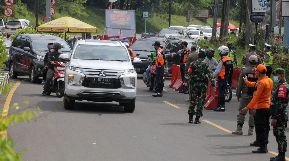 <p>Sejumlah petugas gabungan kepolisian,TNI dan Satpol PP  tengah melakukan penyekatan menuju jalur wisata Puncak Bogor, Sabtu 15 Mei 2021. Foto : Panji Asmoro/TrenAsia</p>
