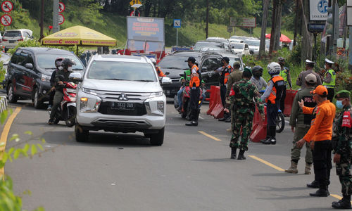 <p>Sejumlah petugas gabungan kepolisian,TNI dan Satpol PP  tengah melakukan penyekatan menuju jalur wisata Puncak Bogor, Sabtu 15 Mei 2021. Foto : Panji Asmoro/TrenAsia</p>
