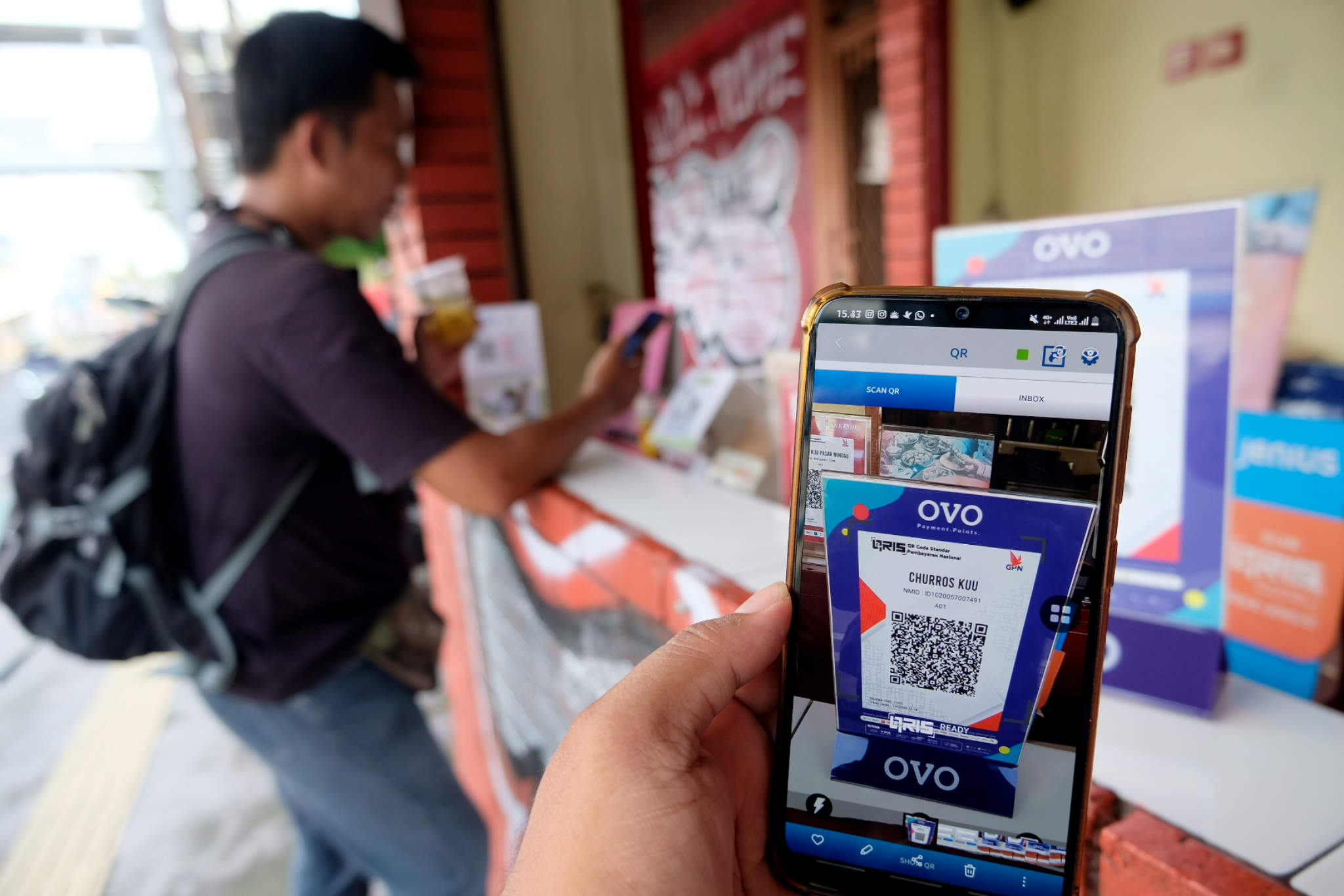 <p>Warga memindai kode batang atau QR Code saat bertransaksi digital di gerai makanan dan minuman ringan siap saji di kawasan Pasar Minggu, Jakarta, Selasa, 18 Mei 2021. Foto: Ismail Pohan/TrenAsia</p>
