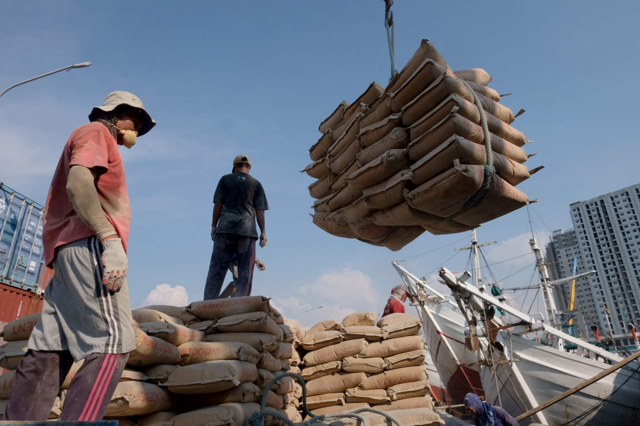 <p>Pekerja melakukan bongkar muat semen yang akan dimasukkan ke dalam kapal muatan barang di dermaga Pelabuhan Sunda Kelapa, Jakarta, Rabu,  19 Mei 2021. Foto: Ismail Pohan/TrenAsia</p>
