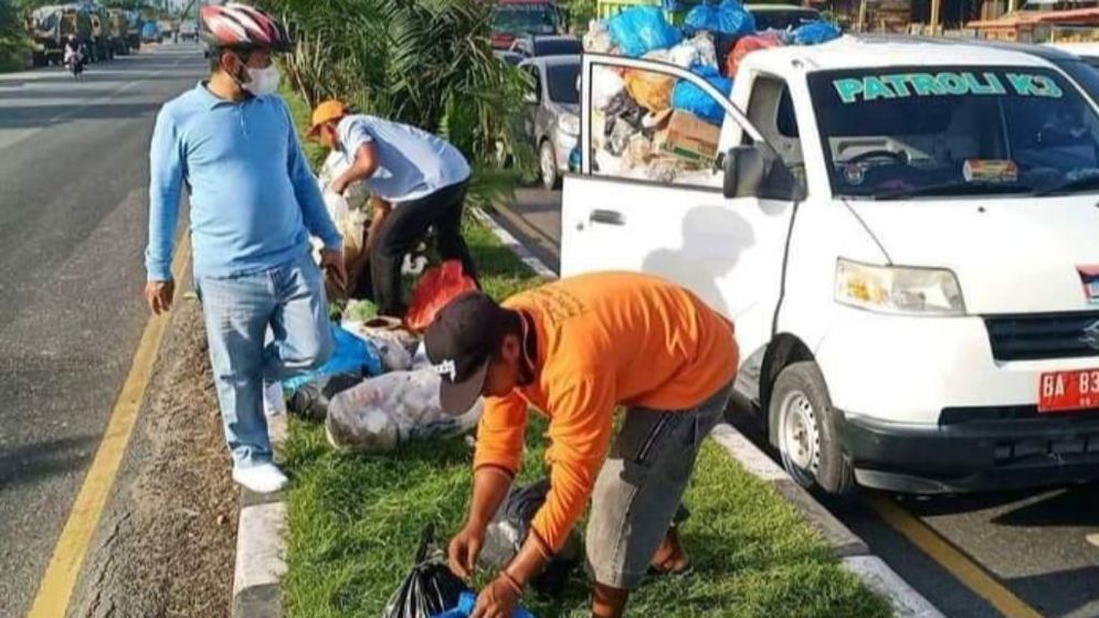 Petugas tengah memungut sampah