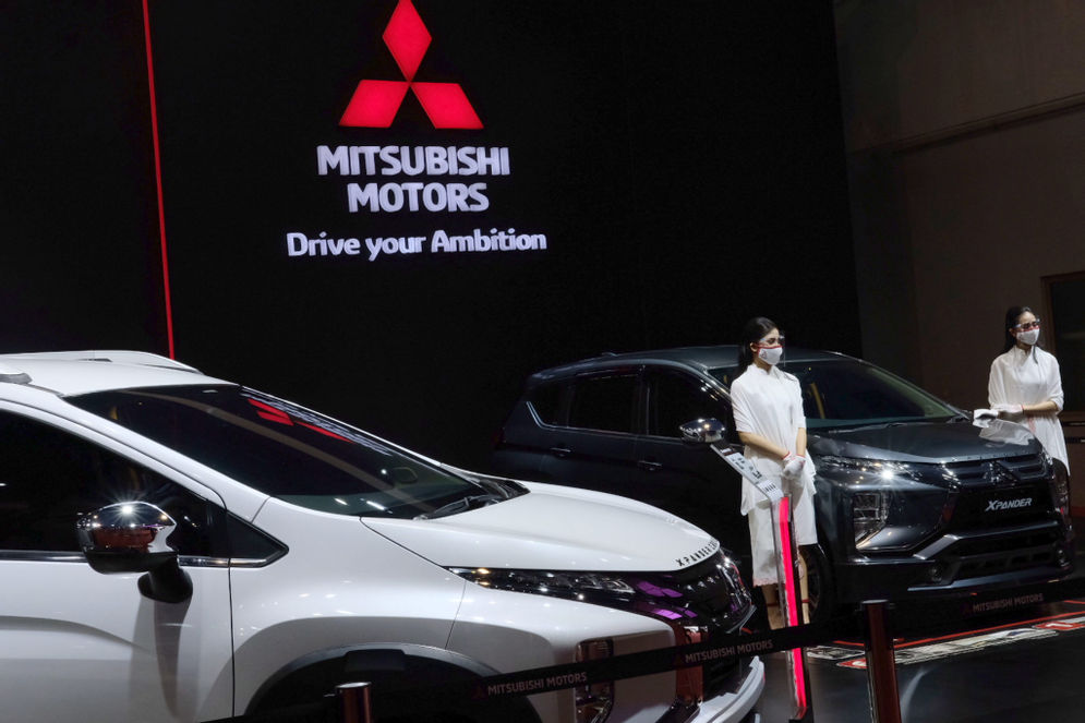 Model berpose di dekat mobil Mitsubishi yang dipamerkan pada ajang Indonesia International Motor Show (IIMS) Hybrid 2021, di JIEXpo Kemayoran, Jakarta, Jum’at, 16 April 2021. 
