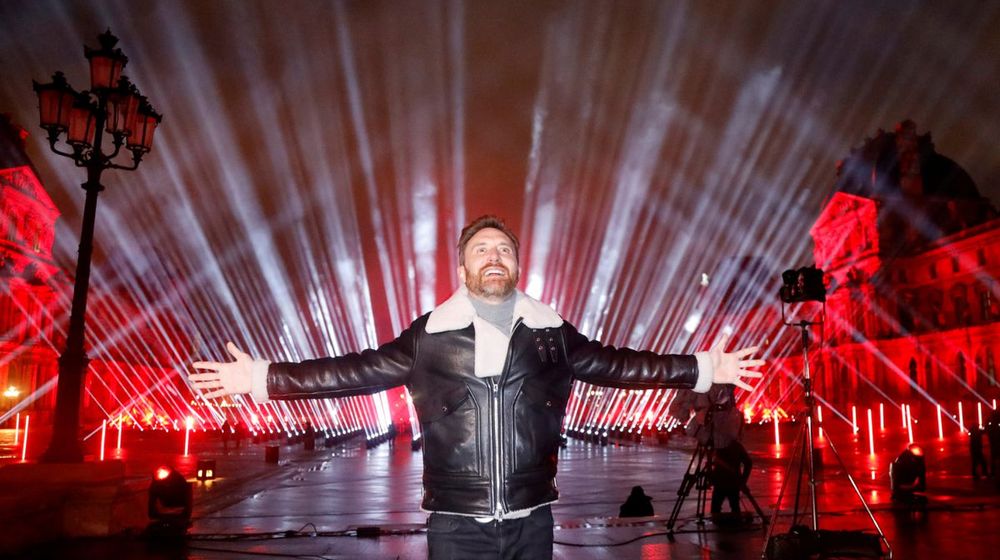 <p>DJ Prancis David Guetta berpose di depan Piramida Louvre sebelum melakukan konser penggalangan dana ‘United at Home’ untuk Malam Tahun Baru, di Paris, Prancis, 29 Desember 2020. REUTERS/Charles Platiau</p>
