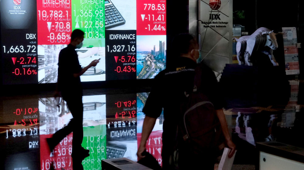 <p>Karyawan melintas di depan layar pergerakan indeks harga saham gabungan (IHSG) gedung Bursa Efek Indonesia (BEI) Jakarta, Senin, 21 Juni 2021. Foto: Ismail Pohan/TrenAsia</p>
