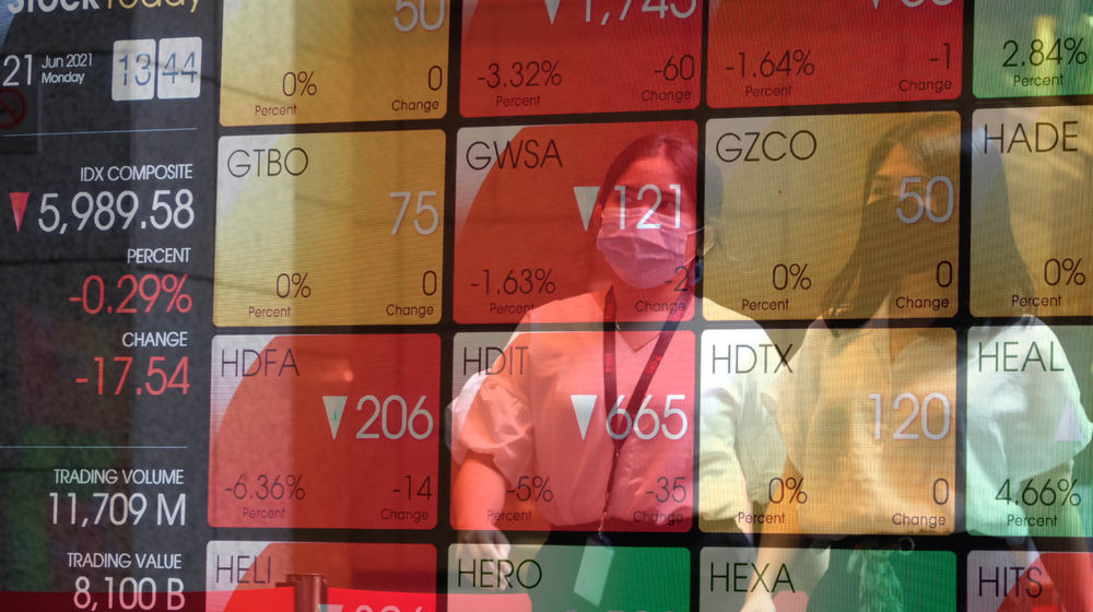 <p>Karyawan melintas di depan layar pergerakan indeks harga saham gabungan (IHSG) gedung Bursa Efek Indonesia (BEI) Jakarta, Senin, 21 Juni 2021. Foto: Ismail Pohan/TrenAsia</p>
