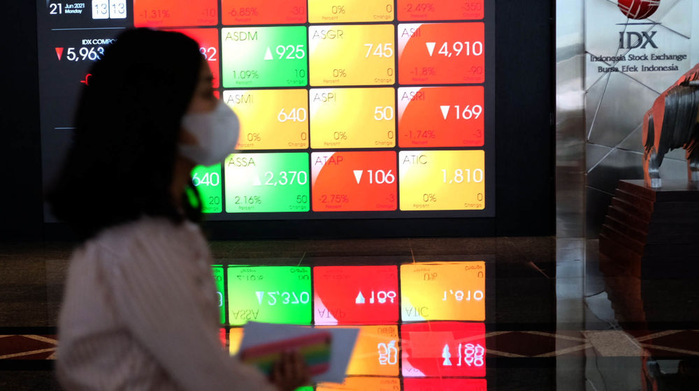 <p>Karyawan melintas di depan layar pergerakan indeks harga saham gabungan (IHSG) gedung Bursa Efek Indonesia (BEI) Jakarta, Senin, 21 Juni 2021. Foto: Ismail Pohan/TrenAsia</p>

