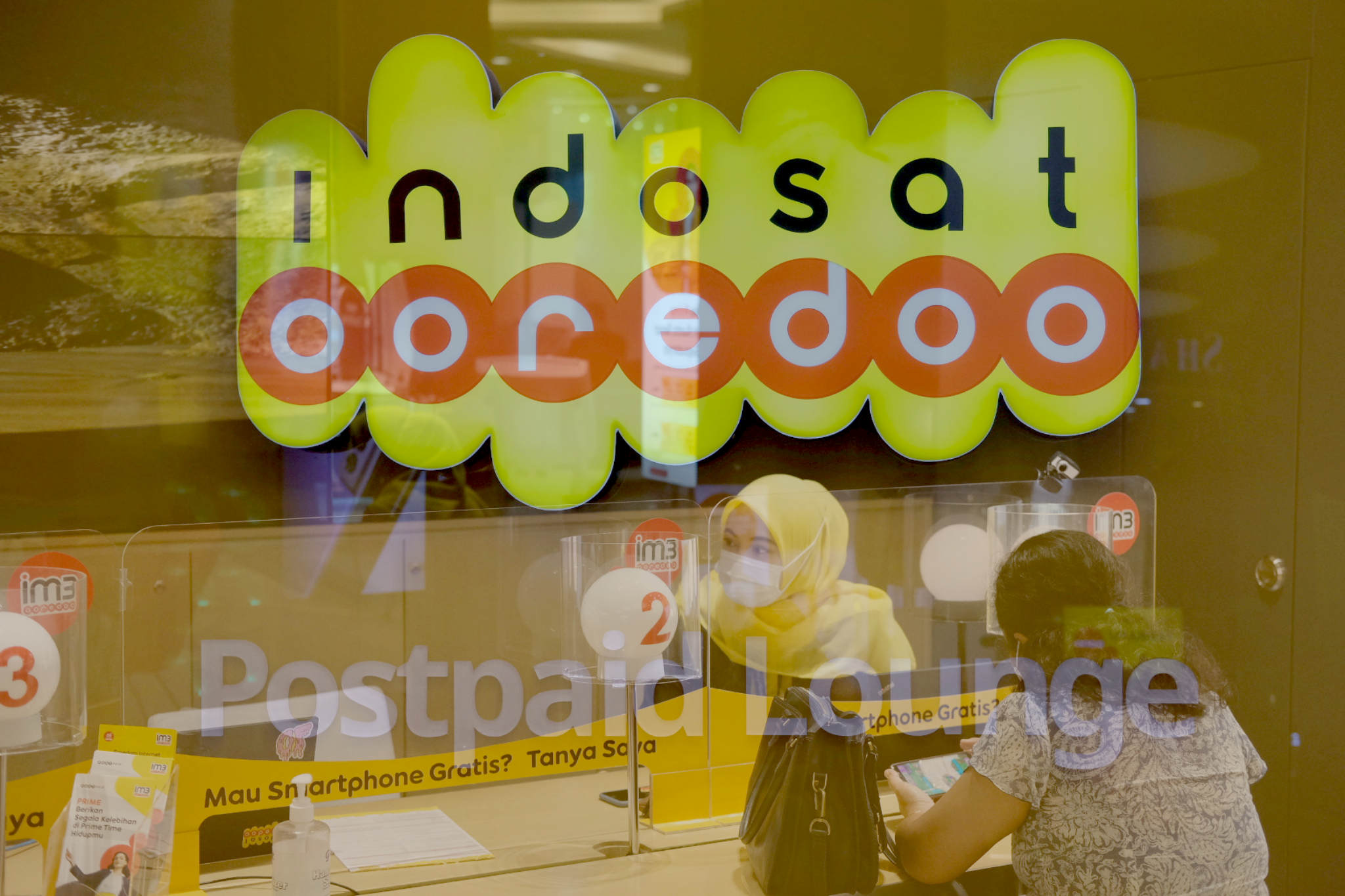 <p>Karyawati melayani pelanggan di salah satu Gerai Indosat Ooredoo di Jakarta, Rabu, 23 Juni 2021. Foto: Ismail Pohan/TrenAsia</p>
