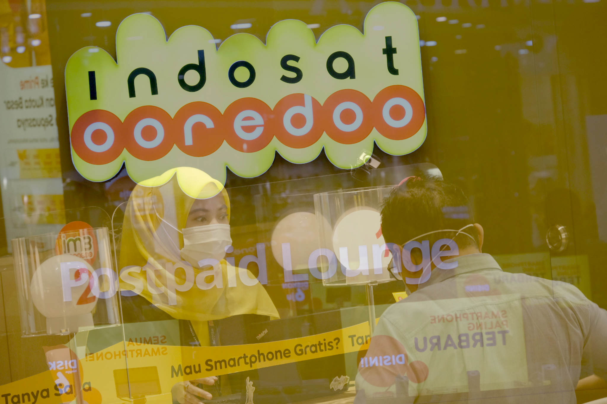 <p>Karyawati melayani pelanggan di salah satu Gerai Indosat Ooredoo di Jakarta, Rabu, 23 Juni 2021. Foto: Ismail Pohan/TrenAsia</p>
