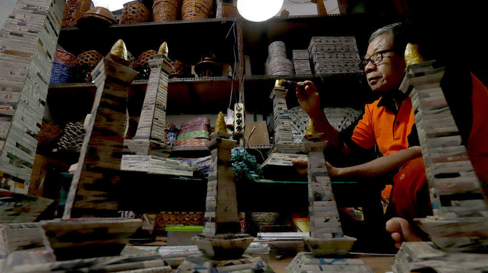 <p>Sugito (68) menyelesaikan pembuatan miniatur Monas dari kertas koran bekas di Bank Sampah Tri Alam Lestari, Pesanggrahan, Jakarta Selatan, Kamis, 10 Juni 2021. Foto: Ismail Pohan/TrenAsia</p>
