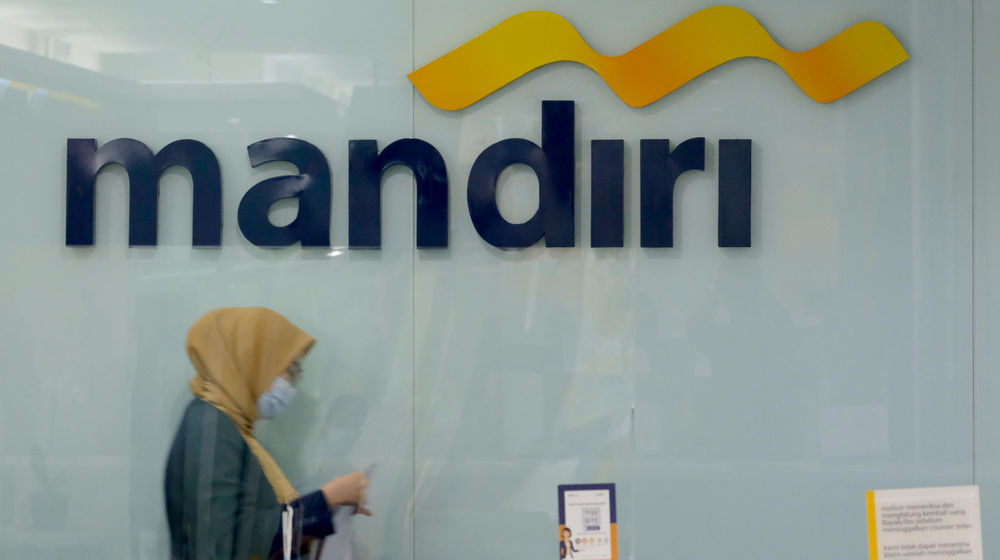 <p>Karyawan melintas di dekat logo di kantor cabang Bank Mandiri, Plaza Mandiri, Gatot Subroto, Jakarta, Selasa, 8 Juni 2021. Foto: Ismail Pohan/TrenAsia</p>
