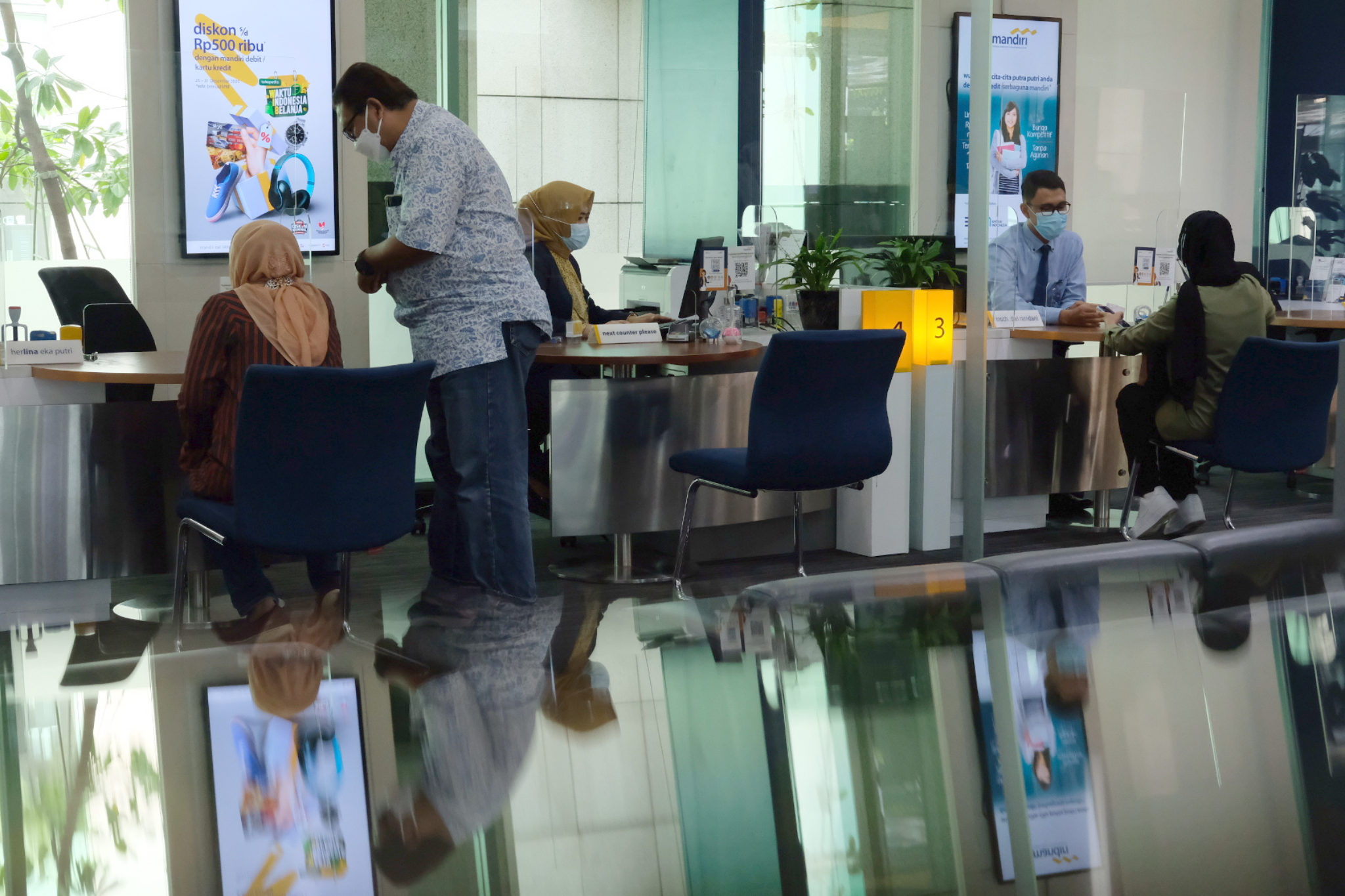 <p>Karyawan melayani nasabah di kantor cabang Bank Mandiri, Plaza Mandiri, Gatot Subroto, Jakarta, Selasa, 8 Juni 2021. Foto: Ismail Pohan/TrenAsia</p>
