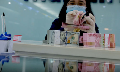 <p>Karyawati salah satu bank menunjukkan mata uang Rupiah dan Dolar di Jakarta, Selasa, 8 Juni 2021. Foto: Ismail Pohan/TrenAsia</p>
