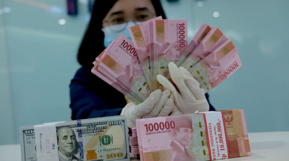 <p>Karyawati salah satu bank menunjukkan mata uang Rupiah dan Dolar di Jakarta, Selasa, 8 Juni 2021. Foto: Ismail Pohan/TrenAsia</p>