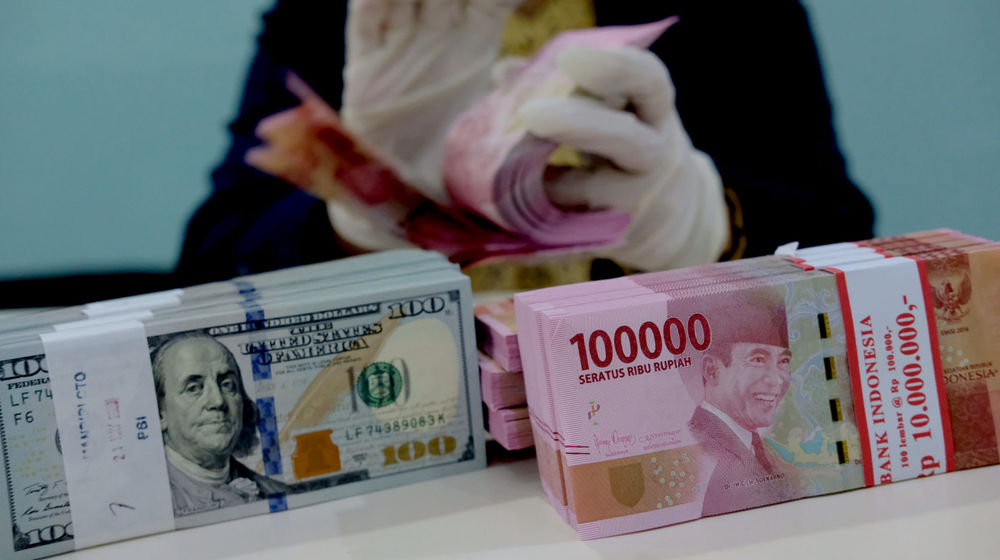 <p>Karyawati salah satu bank menunjukkan mata uang Rupiah dan Dolar di Jakarta, Selasa, 8 Juni 2021. Foto: Ismail Pohan/TrenAsia</p>
