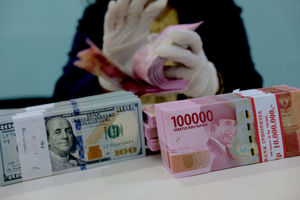 <p>Karyawati salah satu bank menunjukkan mata uang Rupiah dan Dolar di Jakarta, Selasa, 8 Juni 2021. Foto: Ismail Pohan/TrenAsia</p>