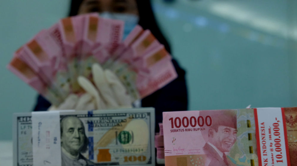 <p>Karyawati salah satu bank menunjukkan mata uang Rupiah dan Dolar di Jakarta, Selasa, 8 Juni 2021. Foto: Ismail Pohan/TrenAsia</p>
