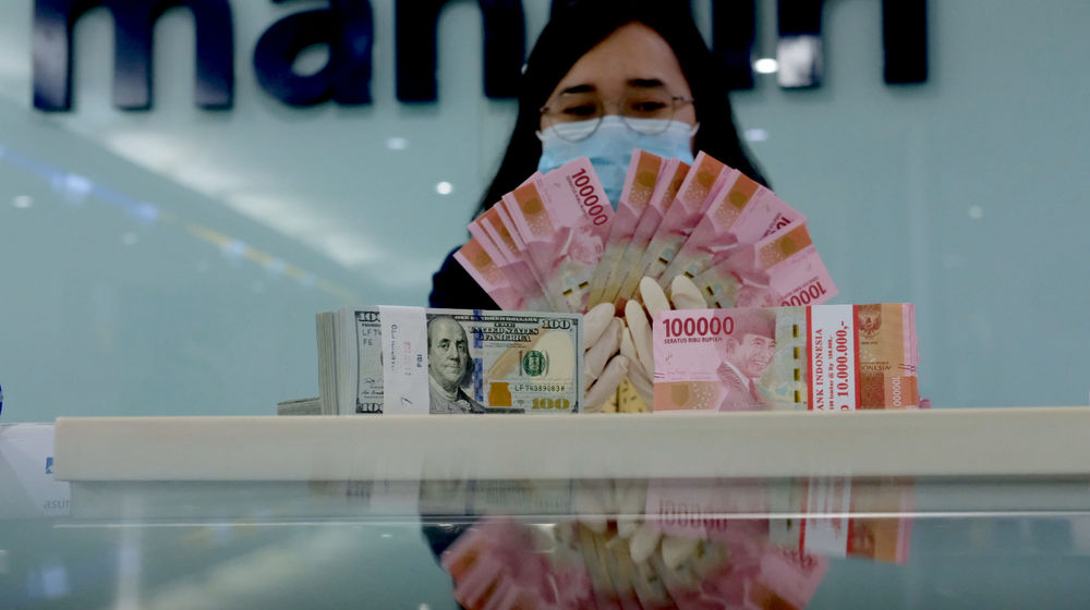 <p>Karyawati salah satu bank menunjukkan mata uang Rupiah dan Dolar di Jakarta, Selasa, 8 Juni 2021. Foto: Ismail Pohan/TrenAsia</p>
