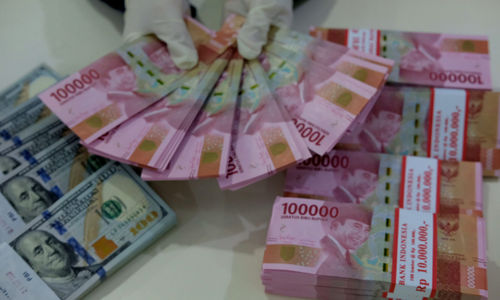 <p>Karyawati salah satu bank menunjukkan mata uang Rupiah dan Dolar di Jakarta, Selasa, 8 Juni 2021. Foto: Ismail Pohan/TrenAsia</p>
