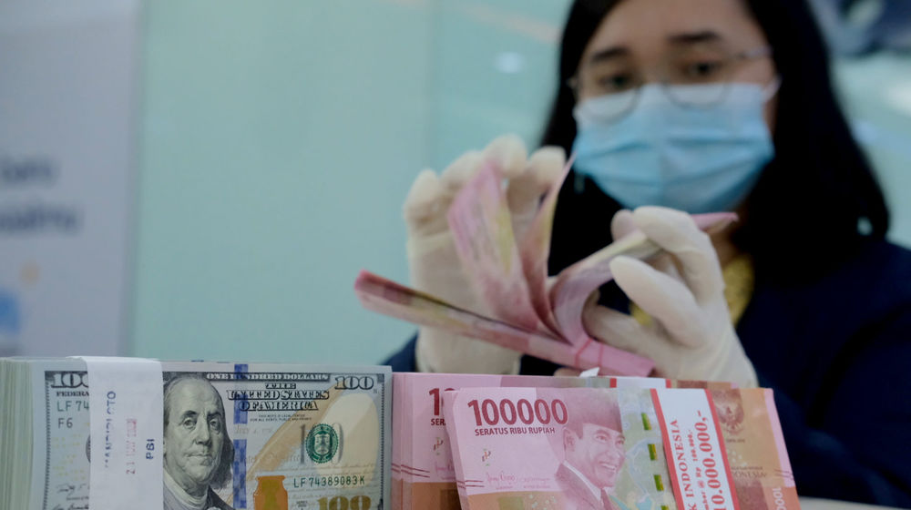 <p>Karyawati salah satu bank menunjukkan mata uang Rupiah dan Dolar di Jakarta, Selasa, 8 Juni 2021. Foto: Ismail Pohan/TrenAsia</p>
