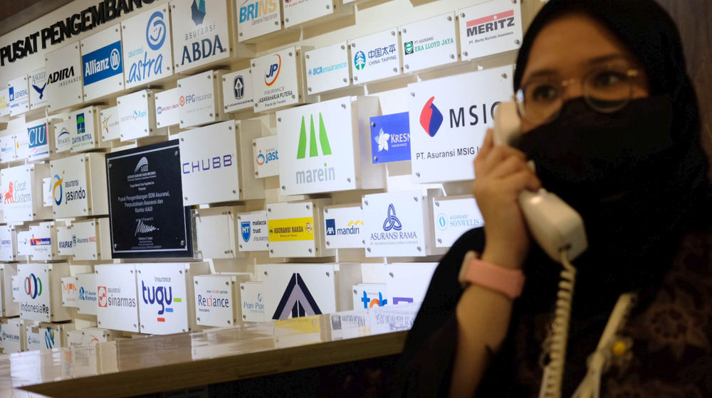 <p>Karyawan beraktivitas di dekat logo sejumlah  asuransi umum Indonesia (AAUI) di Jakarta, Senin, 28 Juni 2021. Foto: Ismail Pohan/TrenAsia</p>
