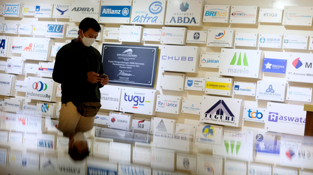 <p>Karyawan beraktivitas di dekat logo sejumlah asuransi umum di Jakarta, Senin, 28 Juni 2021. Foto: Ismail Pohan/TrenAsia</p>
