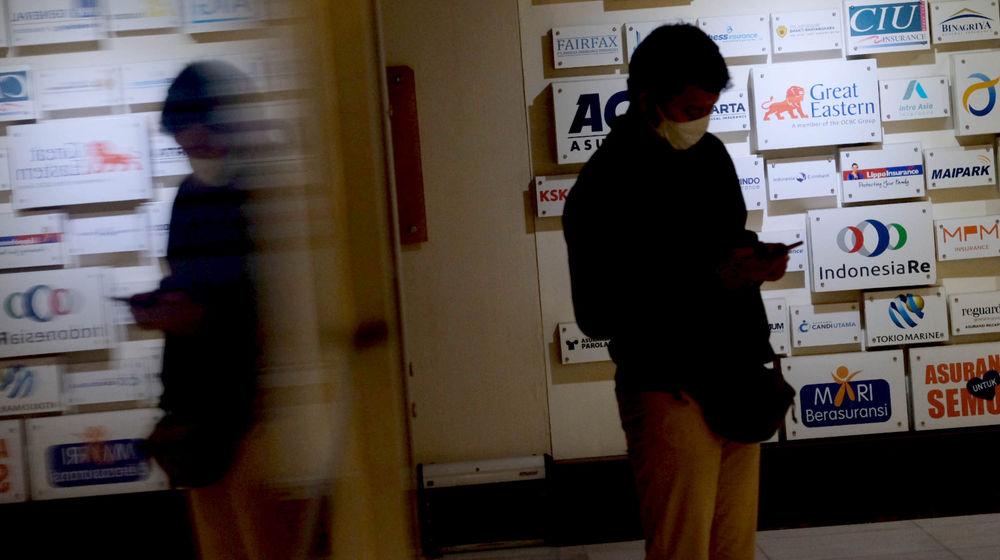 <p>Karyawan beraktivitas di dekat logo sejumlah asuransi umum di Jakarta, Senin, 28 Juni 2021. Foto: Ismail Pohan/TrenAsia</p>
