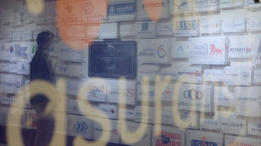 <p>Karyawan beraktivitas di dekat logo sejumlah asuransi umum di Jakarta, Senin, 28 Juni 2021. Foto: Ismail Pohan/TrenAsia</p>
