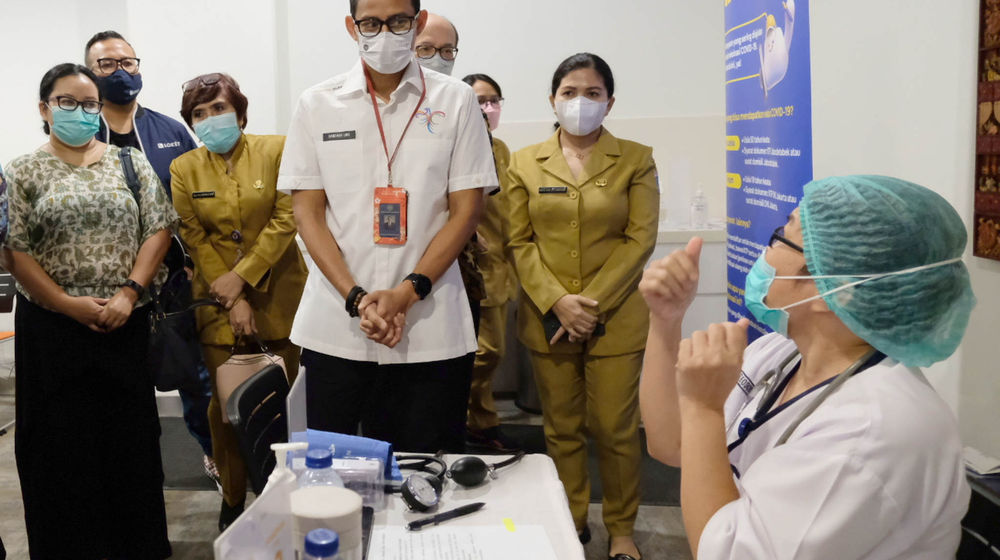 <p>Menteri Pariwisata dan Ekonomi Kreatif Sandiaga Salahuddin Uno (tengah) bersama Chief Public Policy & Government Relations Gojek, Shinto Nugroho (kiri) berbincang dengan nakes saat pemberian vaksin AstraZeneca pada warga usia 18+ pada peresmian Sentra Vaksinasi COVID-19 tiket.com di Rumah Sakit St. Carolus, Jakarta, Senin, 14 Juni 2021. Foto: Ismail Pohan/TrenAsia</p>