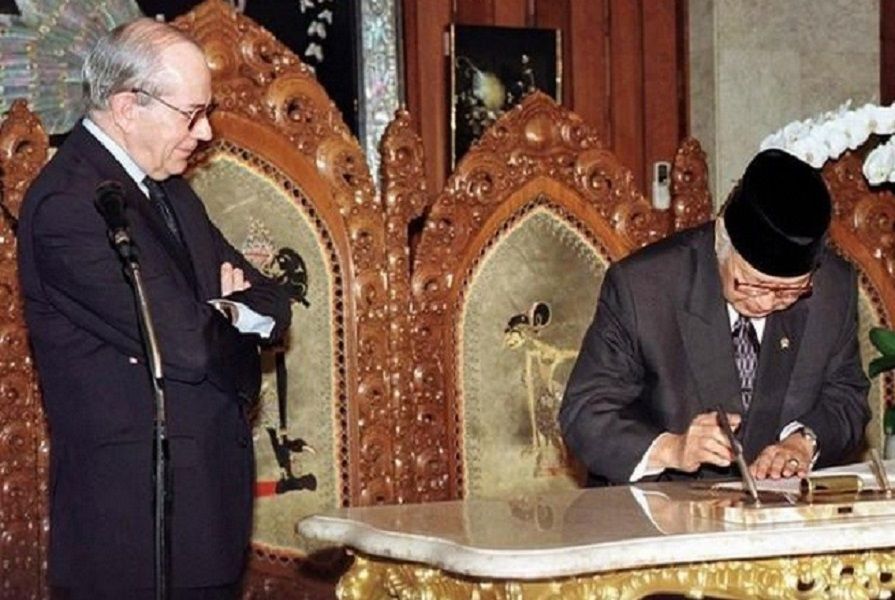 <p>Presiden Soeharto menandatangani perjanjian dengan IMF. Managing Director IMF Michel Camdessus terlihat memandanginya dengan bersedekap. / AP</p>
