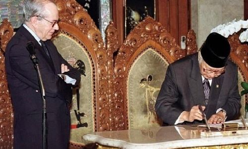 <p>Presiden Soeharto menandatangani perjanjian dengan IMF. Managing Director IMF Michel Camdessus terlihat memandanginya dengan bersedekap. / AP</p>
