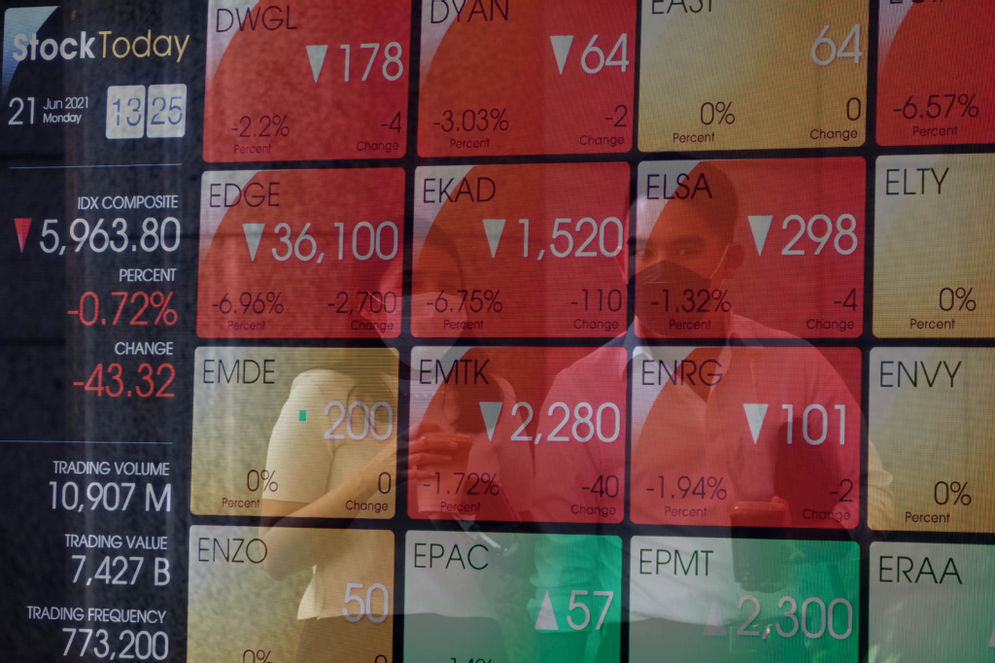 Karyawan melintas di depan layar pergerakan indeks harga saham gabungan (IHSG) gedung Bursa Efek Indonesia (BEI) di Jakarta.