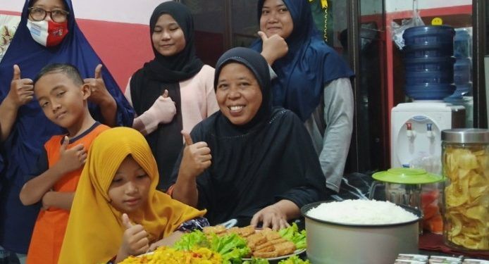 Ami (kiri) saat mengantarkan makanan untuk anak-anak panti asuhan.