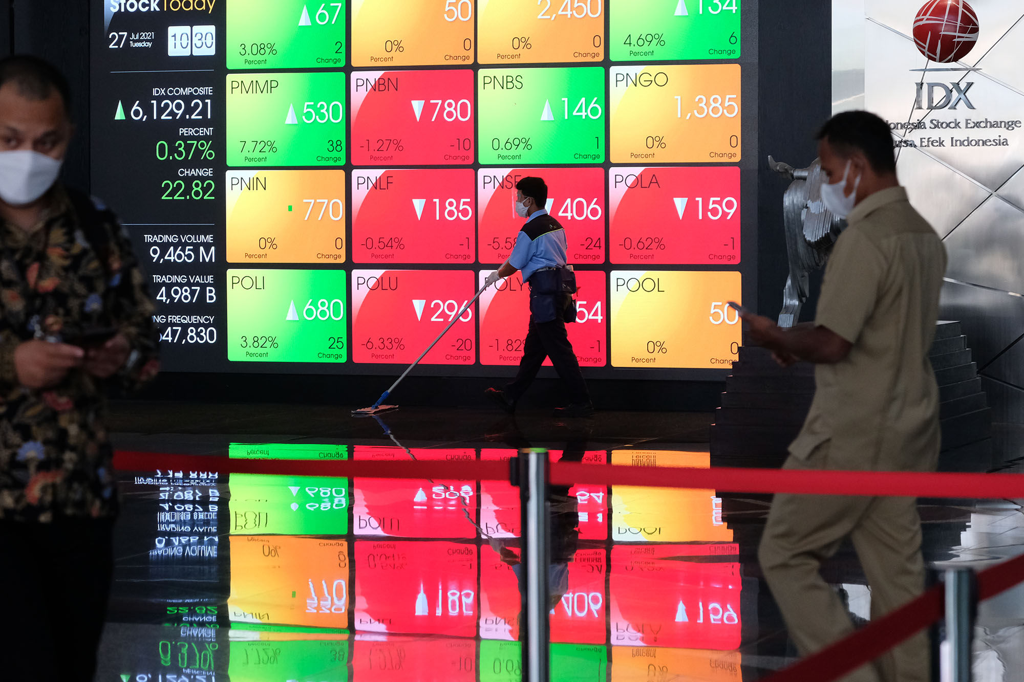 Karyawan melintas dengan latar layar pergerakan indeks harga saham gabungan (IHSG) di gedung Bursa Efek Indonesia (BEI) Jakarta, Selasa, 27 Juli 2021. Foto: Ismail Pohan/TrenAsia