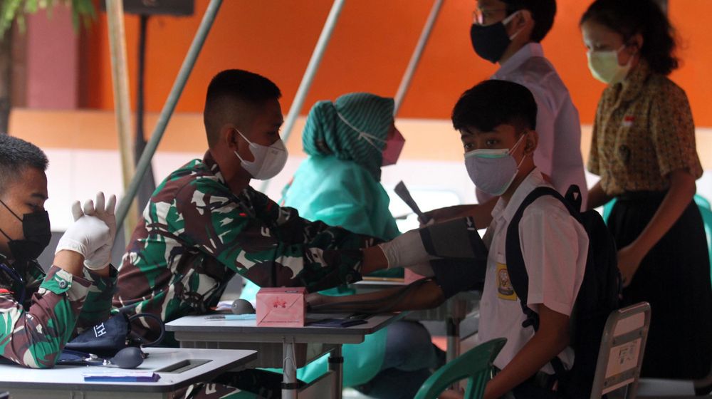 <p>Sejumlah pelajar tengah menjalani pemeriksaan kesehatan dan penyuntikan dalam acara vaksinasi massal serentak untuk pelajar SMP dan SMA di 14 provinsi , Rabu 14 Juli 2021. Foto : Panji Asmoro/TrenAsia</p>
