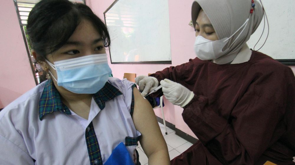 Sejumlah pelajar tengah menjalani pemeriksaan kesehatan dan penyuntikan dalam acara vaksinasi massal serentak untuk pelajar SMP dan SMA di 14 provinsi.