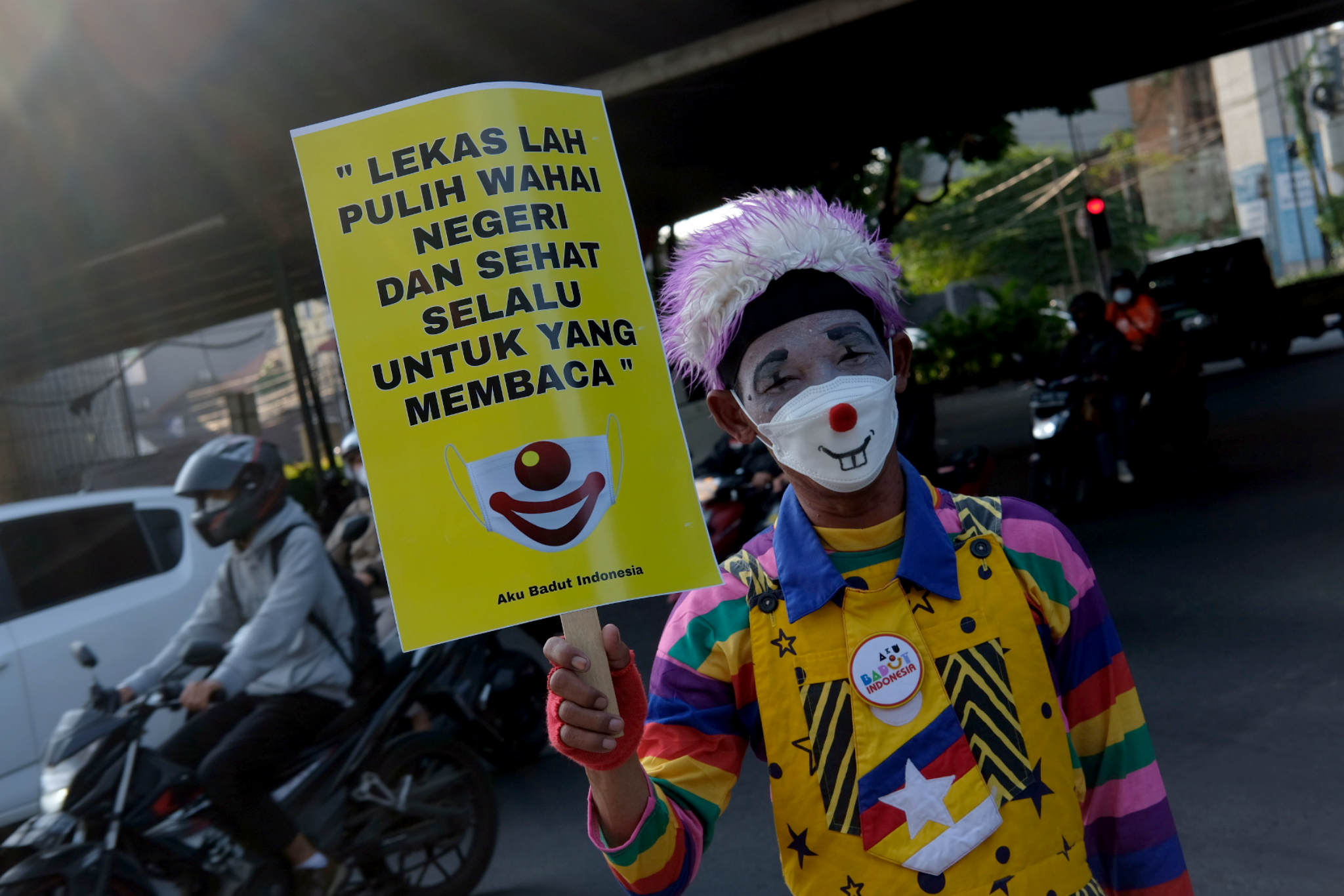 <p>Anggota Komunitas Aku Badut Indonesia(ABI) melakukan aksi kampanye untuk selalu menggunakan masker di kawasan Simpang Fatamawati, Jakarta Selatan, Senin, 12 Juli 2021. Foto: Ismail Pohan/TrenAsia</p>

