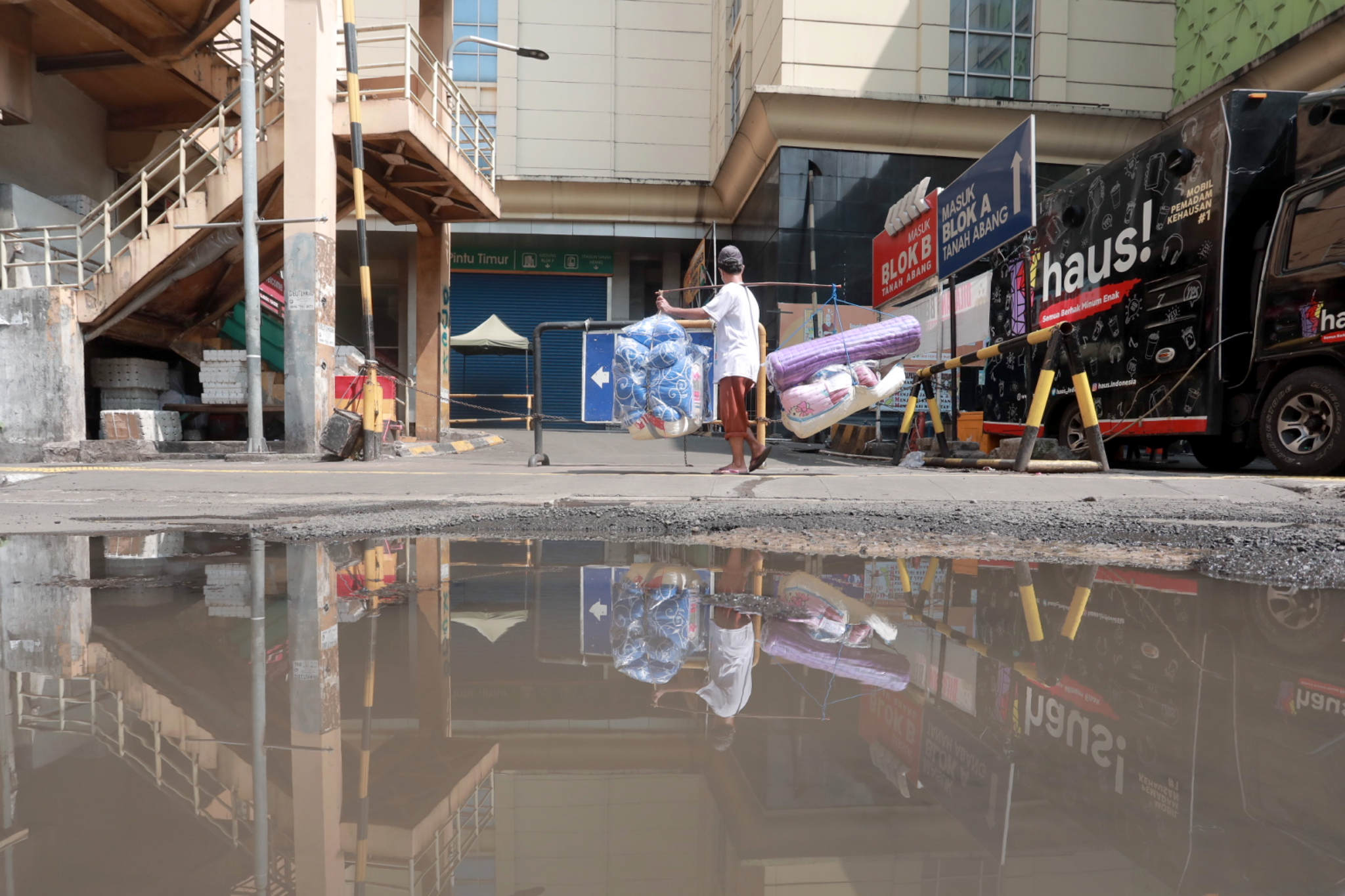 <p>Pedagang melintas di dekat pertokoan Pasar Tanah Abang yang tutup saat Pemberlakuan Pembatasan Kegiatan Masyarakat (PPKM) Darurat di Jakarta, Senin, 5 Juli 2021. Foto: Ismail Pohan/TrenAsia</p>

