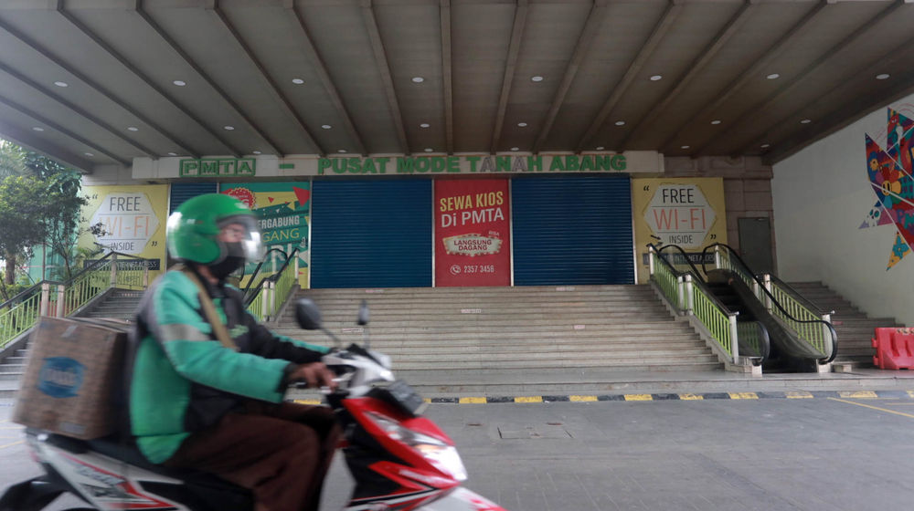 <p>Warga melintas di dekat pertokoan Pasar Tanah Abang yang tutup saat Pemberlakuan Pembatasan Kegiatan Masyarakat (PPKM) Darurat di Jakarta, Senin, 5 Juli 2021. Foto: Ismail Pohan/TrenAsia</p>
