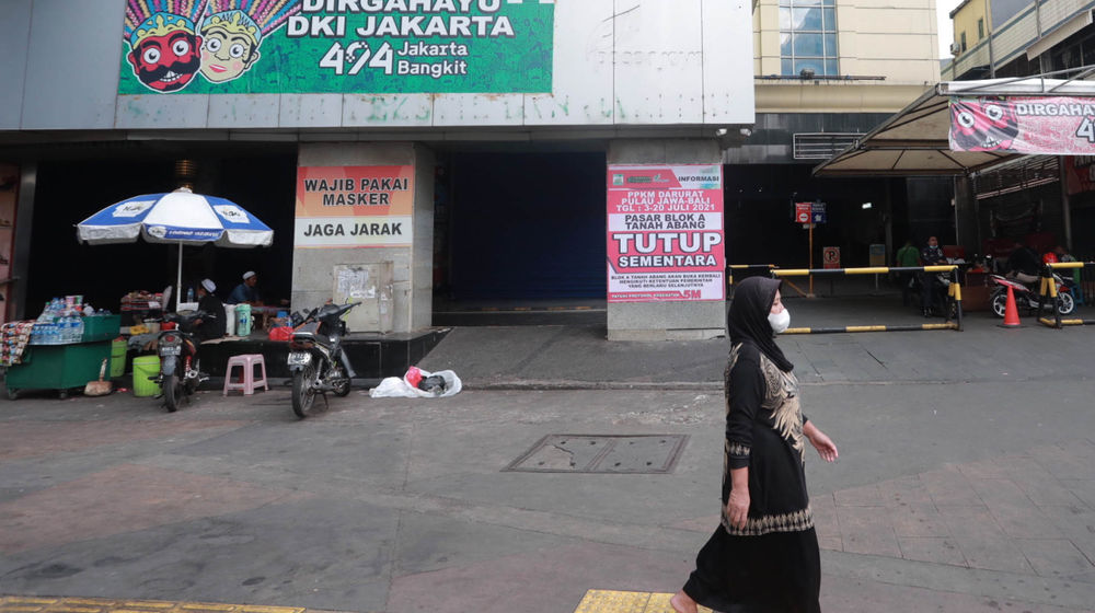<p>Warga melintas di dekat pertokoan Pasar Tanah Abang yang tutup saat Pemberlakuan Pembatasan Kegiatan Masyarakat (PPKM) Darurat di Jakarta, Senin, 5 Juli 2021. Foto: Ismail Pohan/TrenAsia</p>
