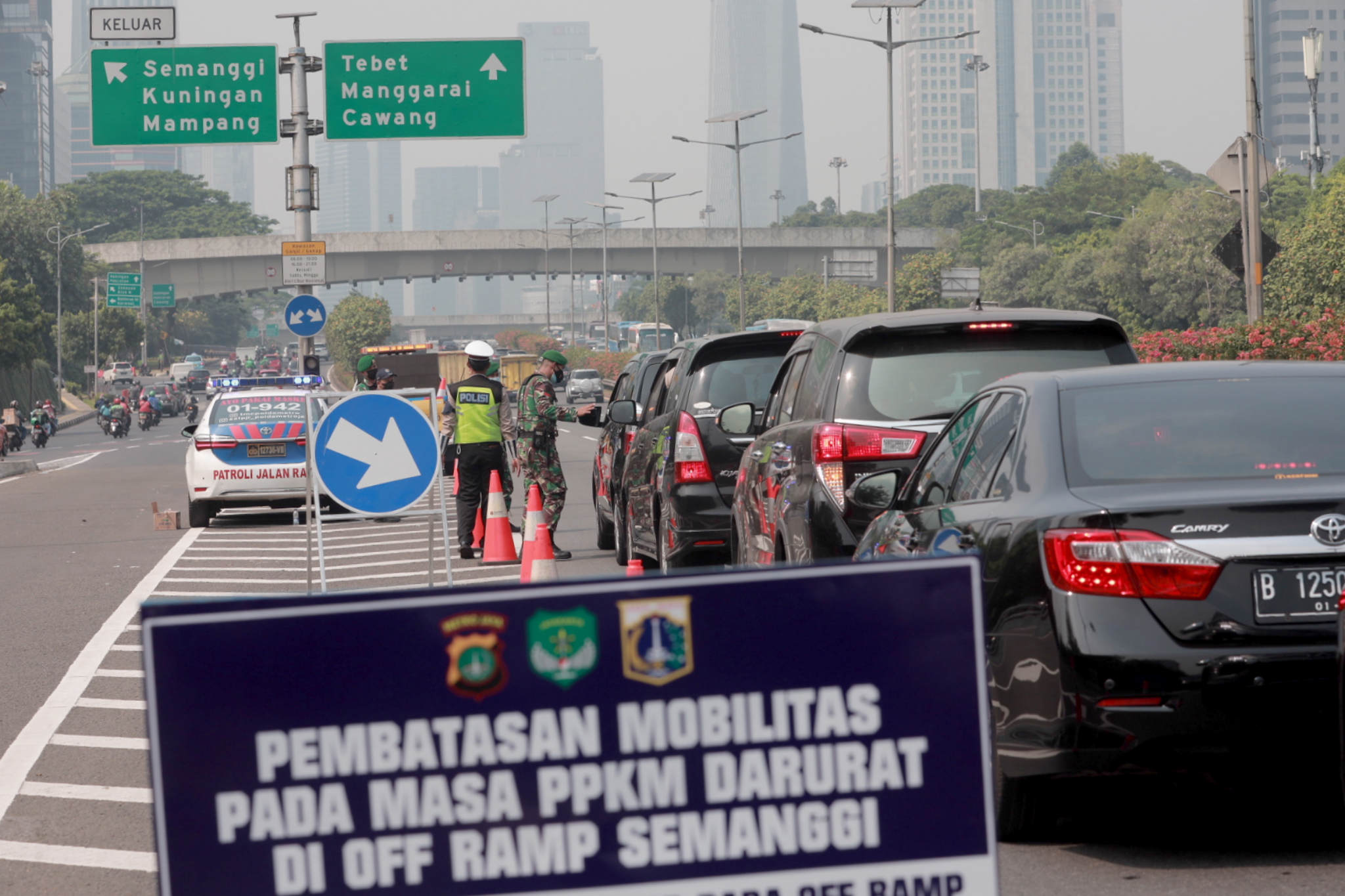 <p>Petugas gabungan memberhentikan kendaraan yang melintas di penyekatan PPKM darurat pintu keluar tol Semanggi, Gatot Subroto, Jakarta, Senin, 5 Juli 2021. Foto: Ismail Pohan/TrenAsia</p>
