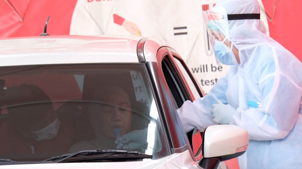 <p>Petugas melayani warga melakukan tes PCR Kumur drive thru di GSI Lab, Cilandak Barat, Jakarta Selatan, Rabu, 14 Juli 2021. Foto: Ismail Pohan/TrenAsia</p>
