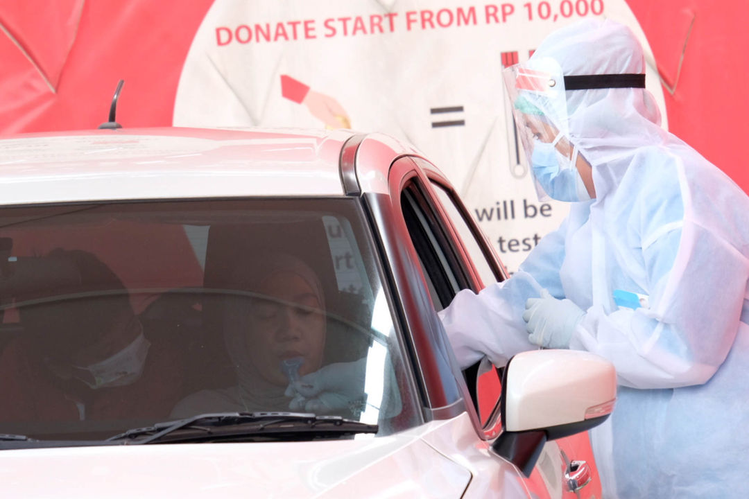 <p>Petugas melayani warga melakukan tes PCR Kumur drive thru di GSI Lab, Cilandak Barat, Jakarta Selatan, Rabu, 14 Juli 2021. Foto: Ismail Pohan/TrenAsia</p>
