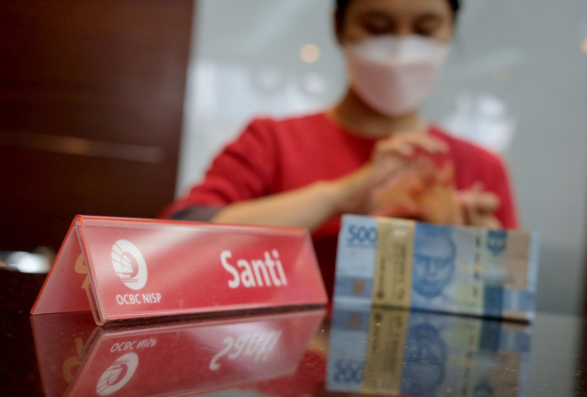 Karyawati menghitung mata uang rupiah di kantor cabang Bank OCBC NISP Jakarta, Senin, 2 Agustus 2021. Foto: Ismail Pohan/TrenAsia