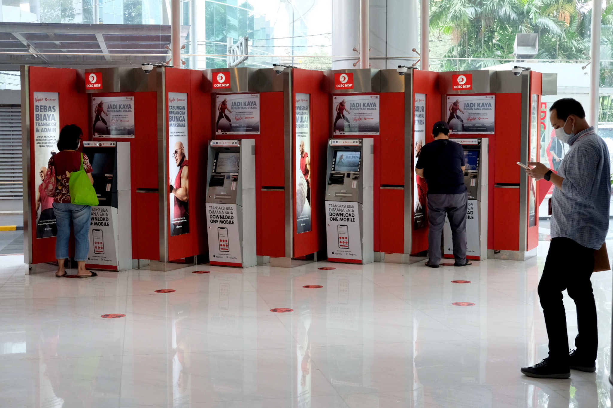 Nasabah melakukan transaksi melalui mesin anjungan tunai mandiri (ATM) di kantor cabang Bank OCBC NISP Jakarta, Senin, 2 Agustus 2021. Foto: Ismail Pohan/TrenAsia